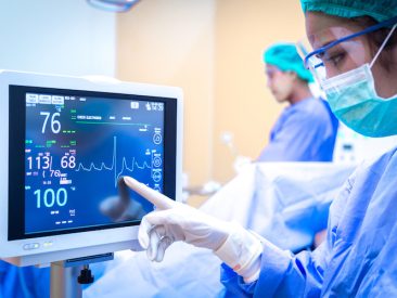Female surgeon using monitor in operating room.